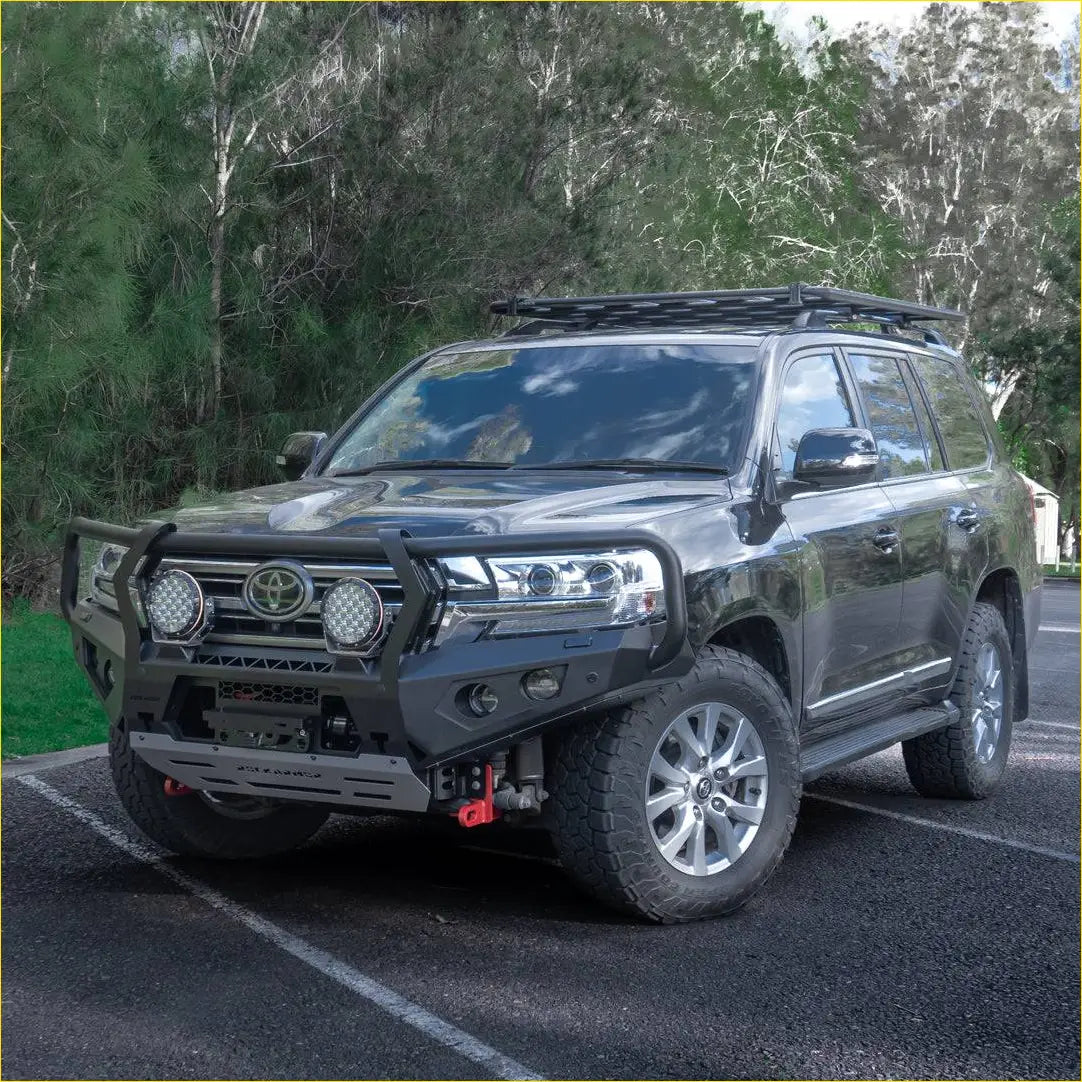 Black toyota land cruiser 300 with rockarmor gt steel hoop steel bullbar featuring rugged front bumper and roof rack