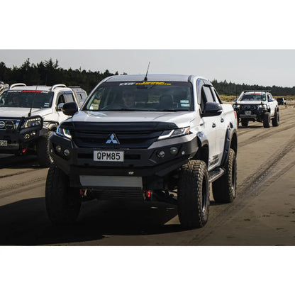 Modified white pickup truck with bull bar, driving lights, and synthetic winch rope