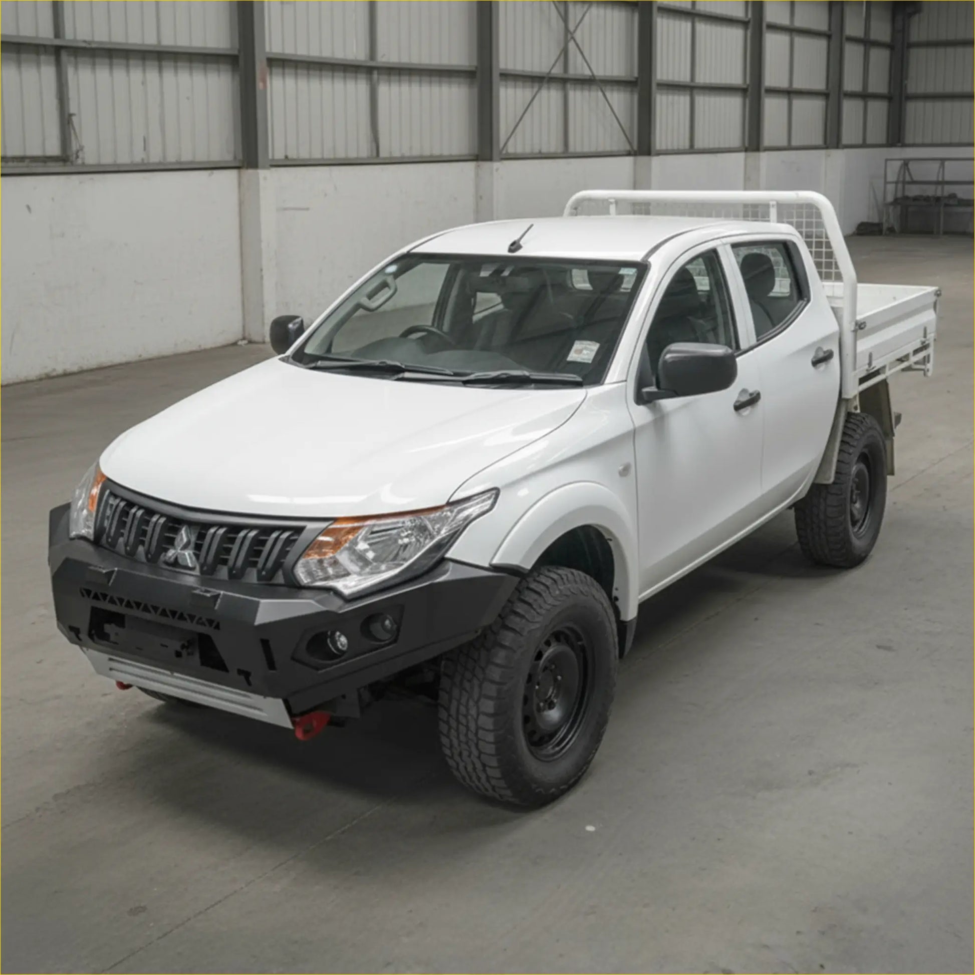 White mitsubishi triton with black steel rockarmor gt hoopless bullbar and rugged off-road tires front view