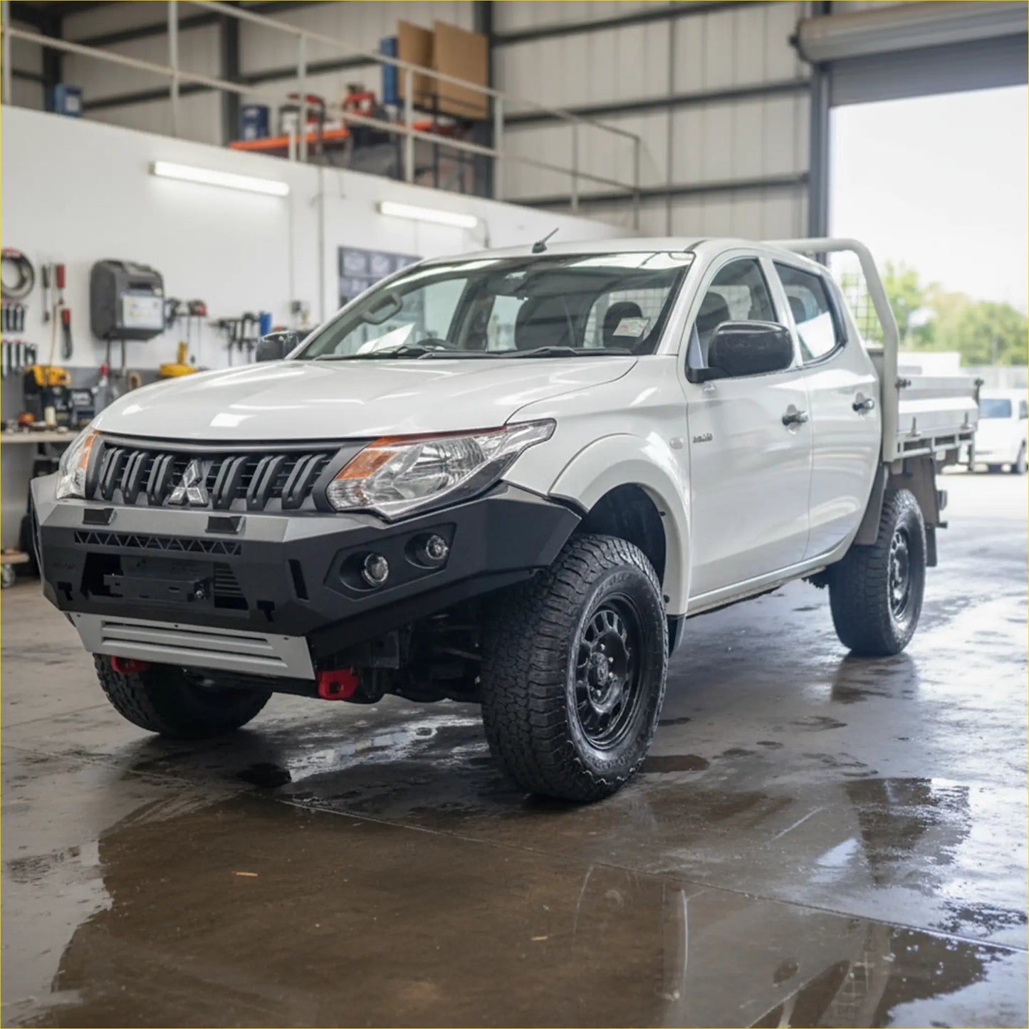White mitsubishi triton with black off-road tires featuring rockarmor gt steel hoopless bullbar rugged front bumper