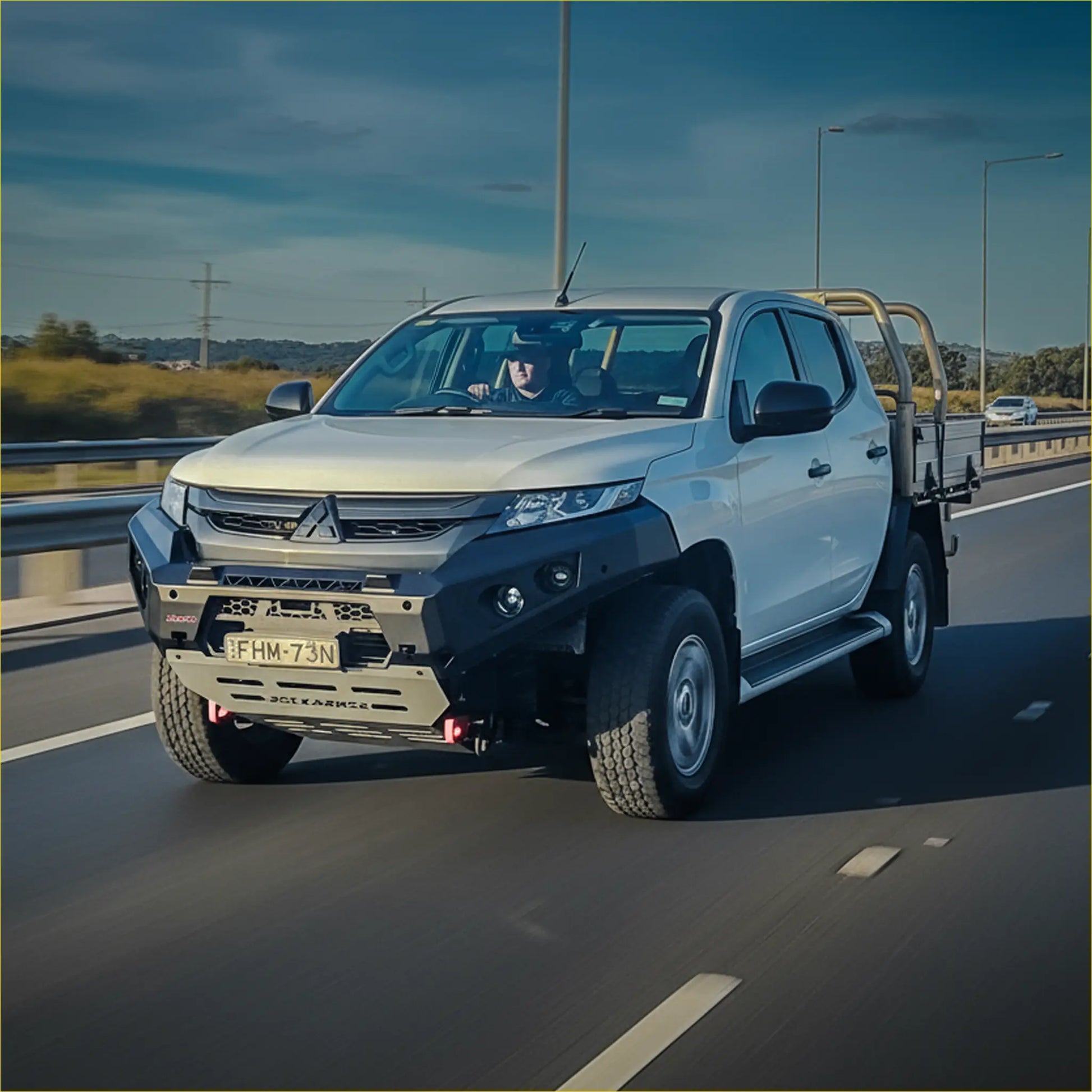 White mitsubishi triton with black steel rockarmor gt hoopless bullbar and yellow roll bars front view