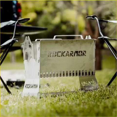 A sleek metallic rockarmor premium camp fire pit and bbq grille with engraved branding perfect for 4wd and offroad use
