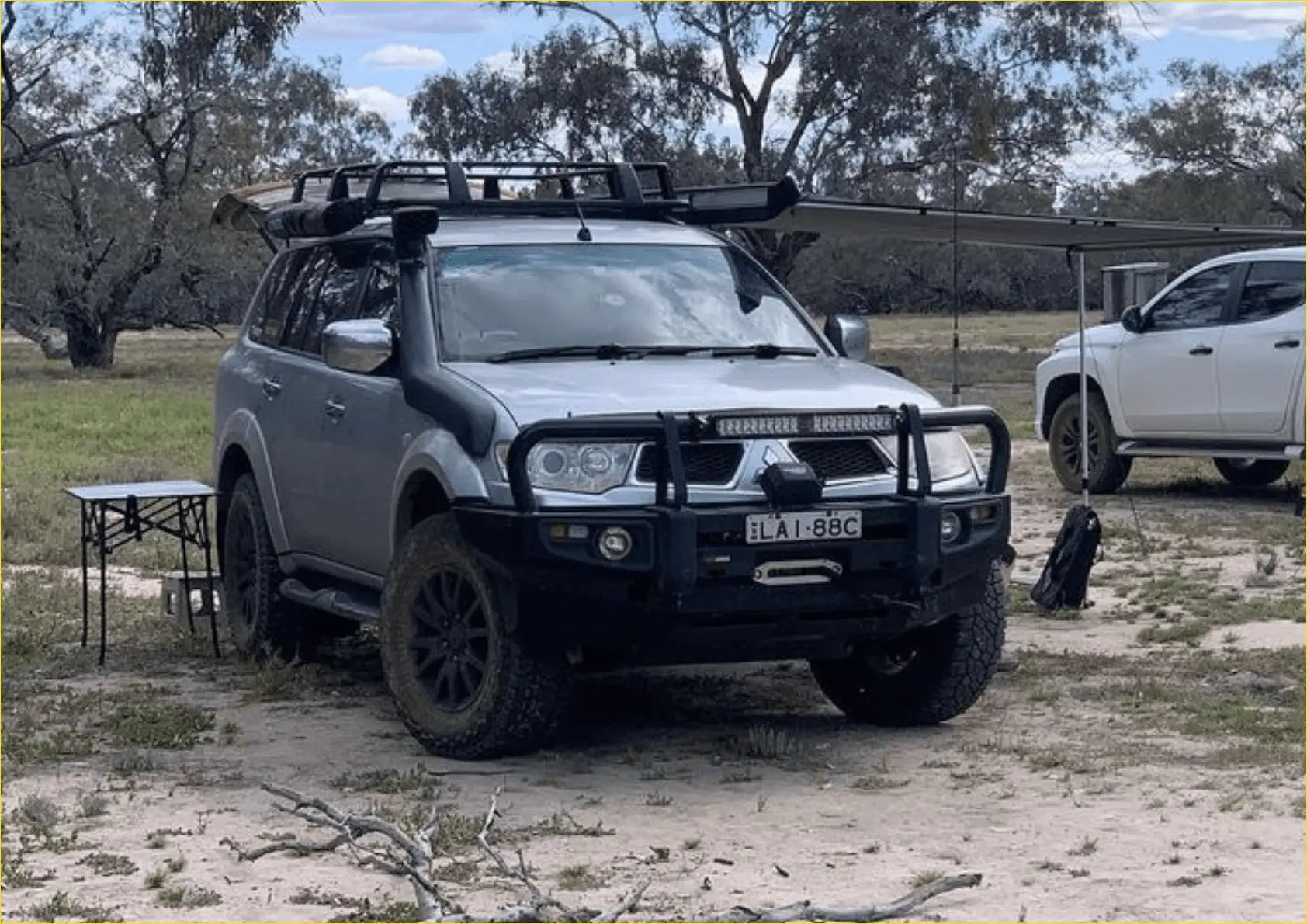 Silver mitsubishi pajero sport with rockarmor premium steel bullbar black off-road tires roof rack and bumper guard