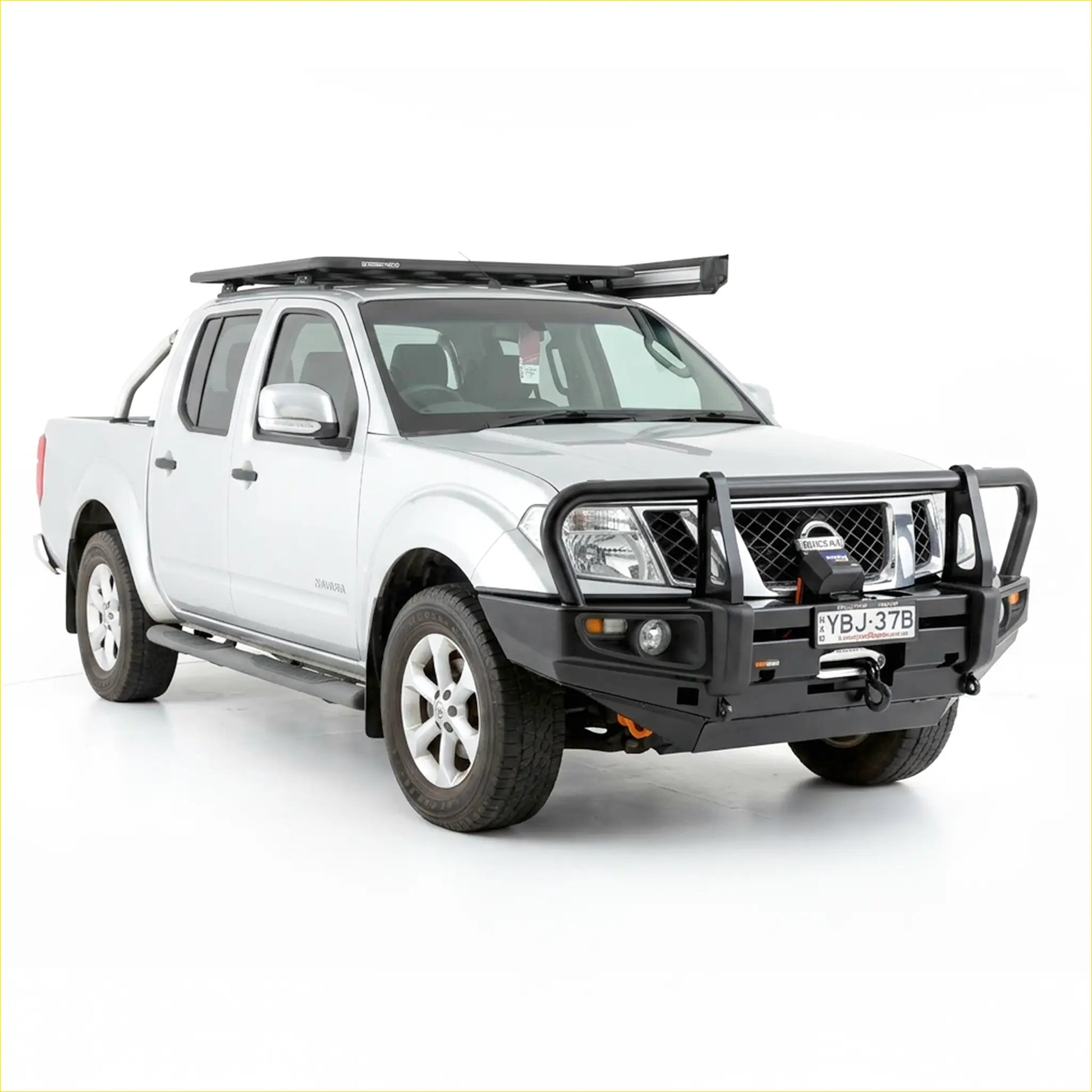 Black rugged steel front bumper with integrated winch and grille guard on white nissan navara d40 2005-2015