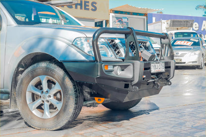 Black metal front bumper guard with integrated lights and tow hook on silver nissan navara d40 pickup truck