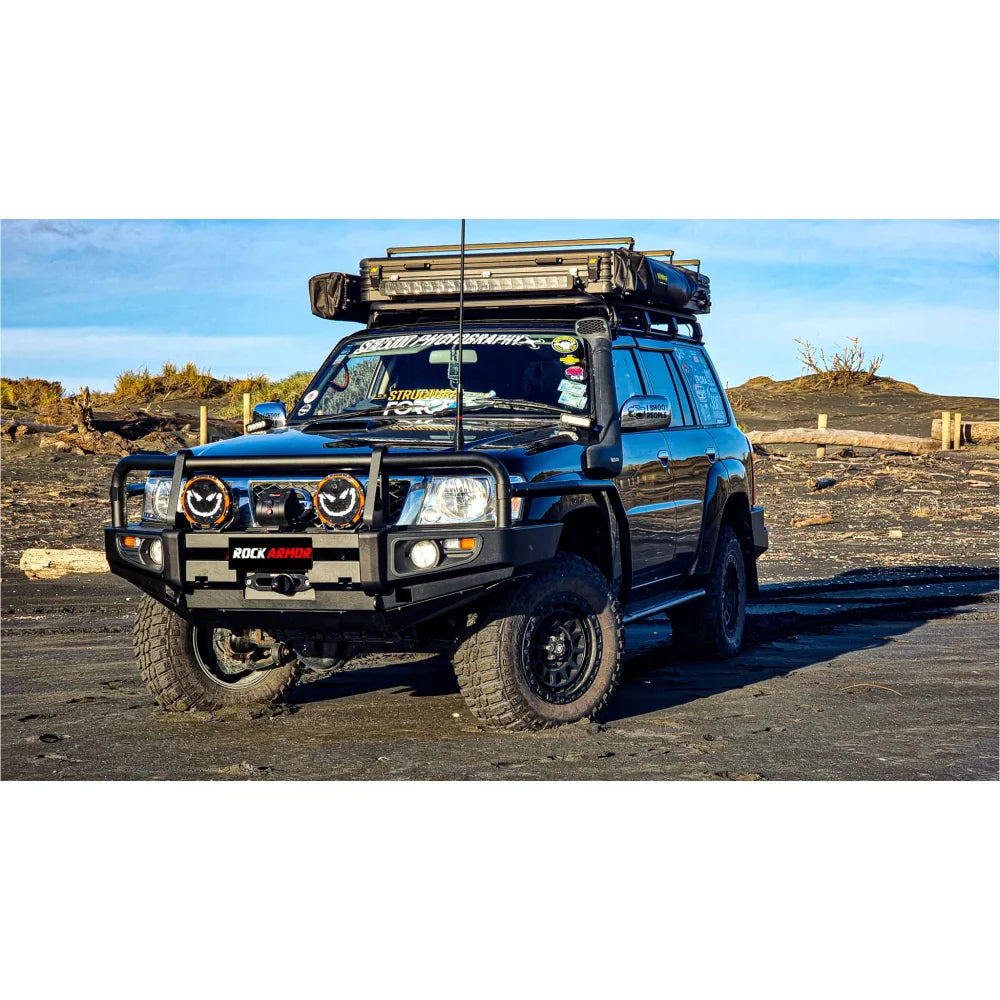 Black off-road vehicle with roof rack showcasing Rockarmor premium steel bullbar with fog lights