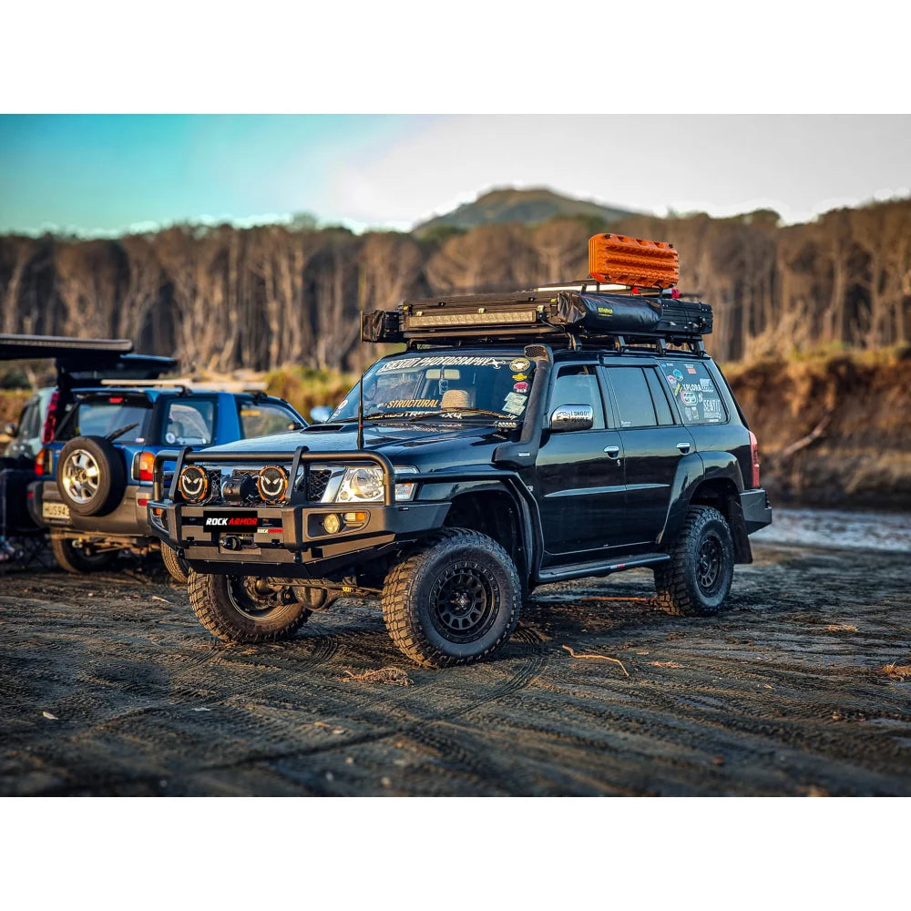 Black off-road vehicle featuring a premium steel bullbar with fog lights for Nissan Patrol GU4