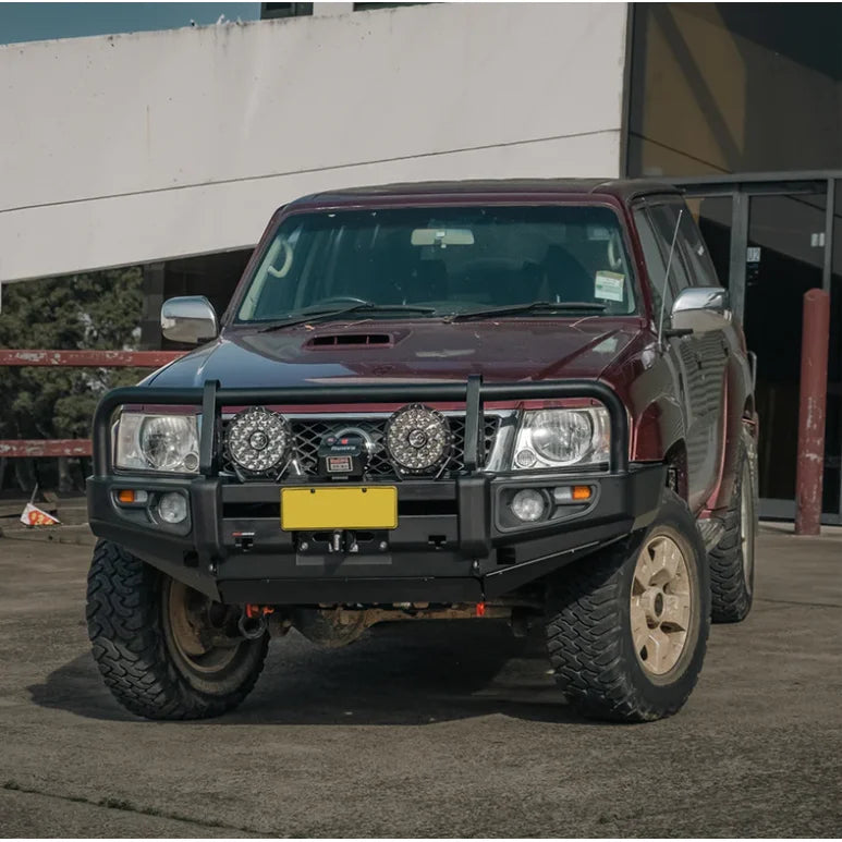 Maroon Nissan Patrol GU4 with premium steel bull bar and fog lights for off-road use