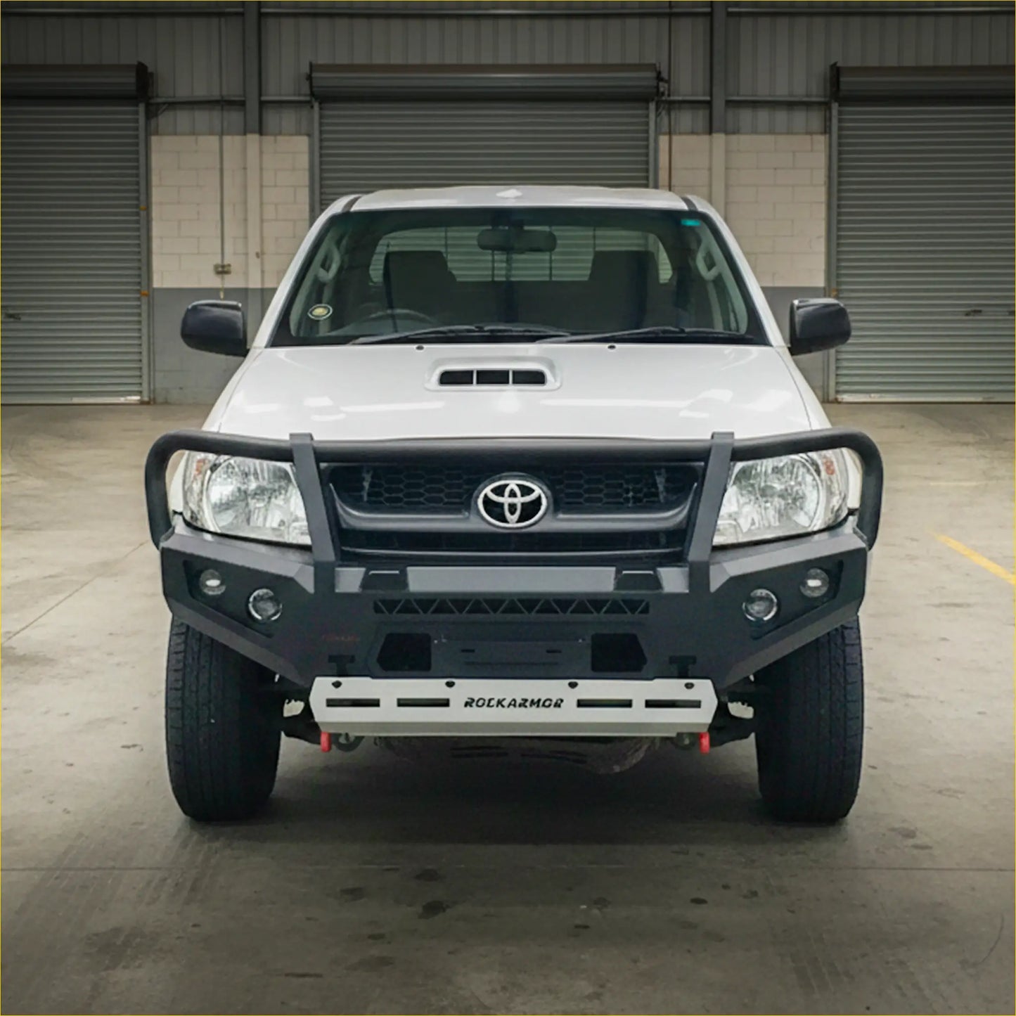 White toyota hilux n70 2005-2011 with a black rokarmor premium steel bullbar front bumper guard and grille