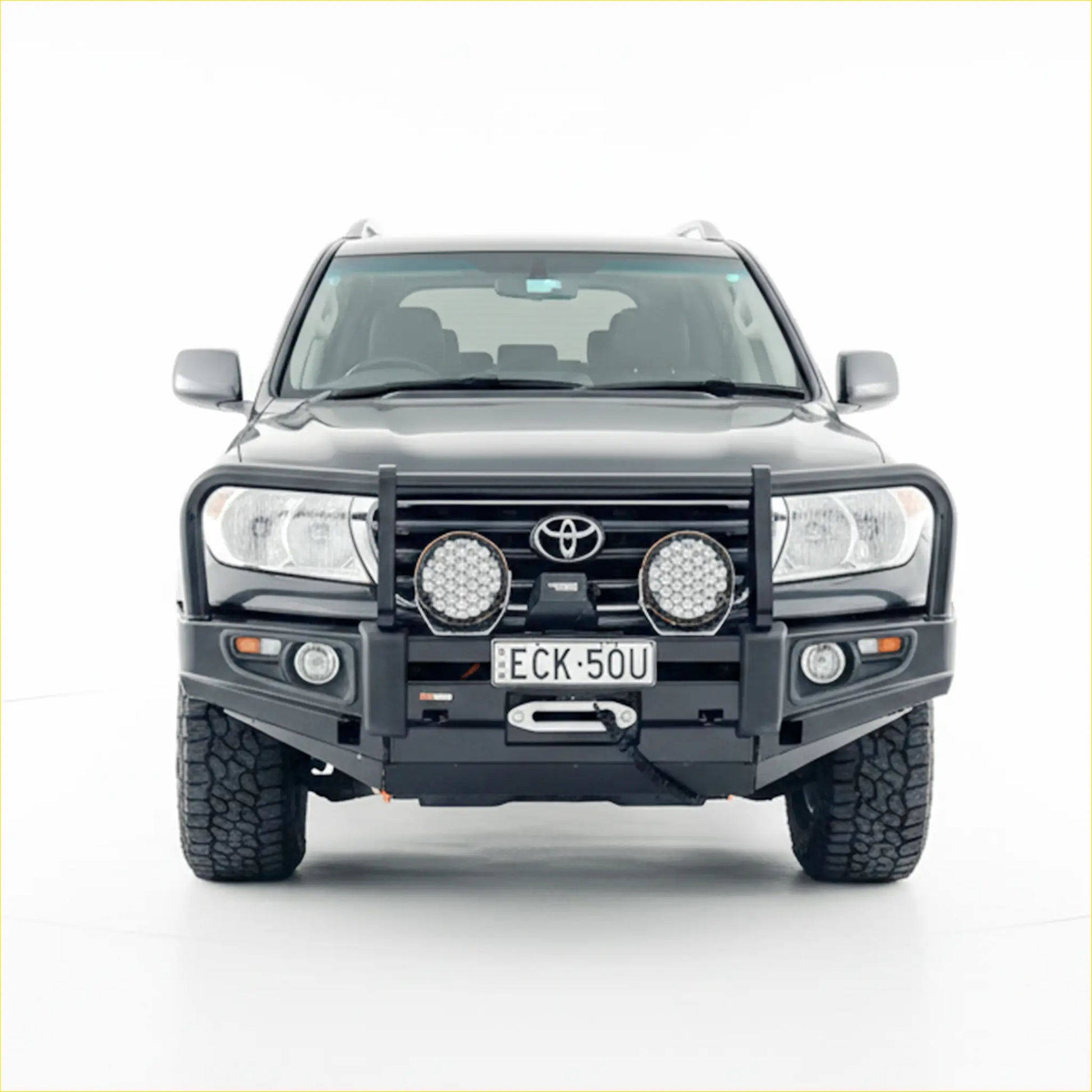 Black toyota land cruiser with rockarmor premium steel bullbar featuring rugged tires and two circular led lights