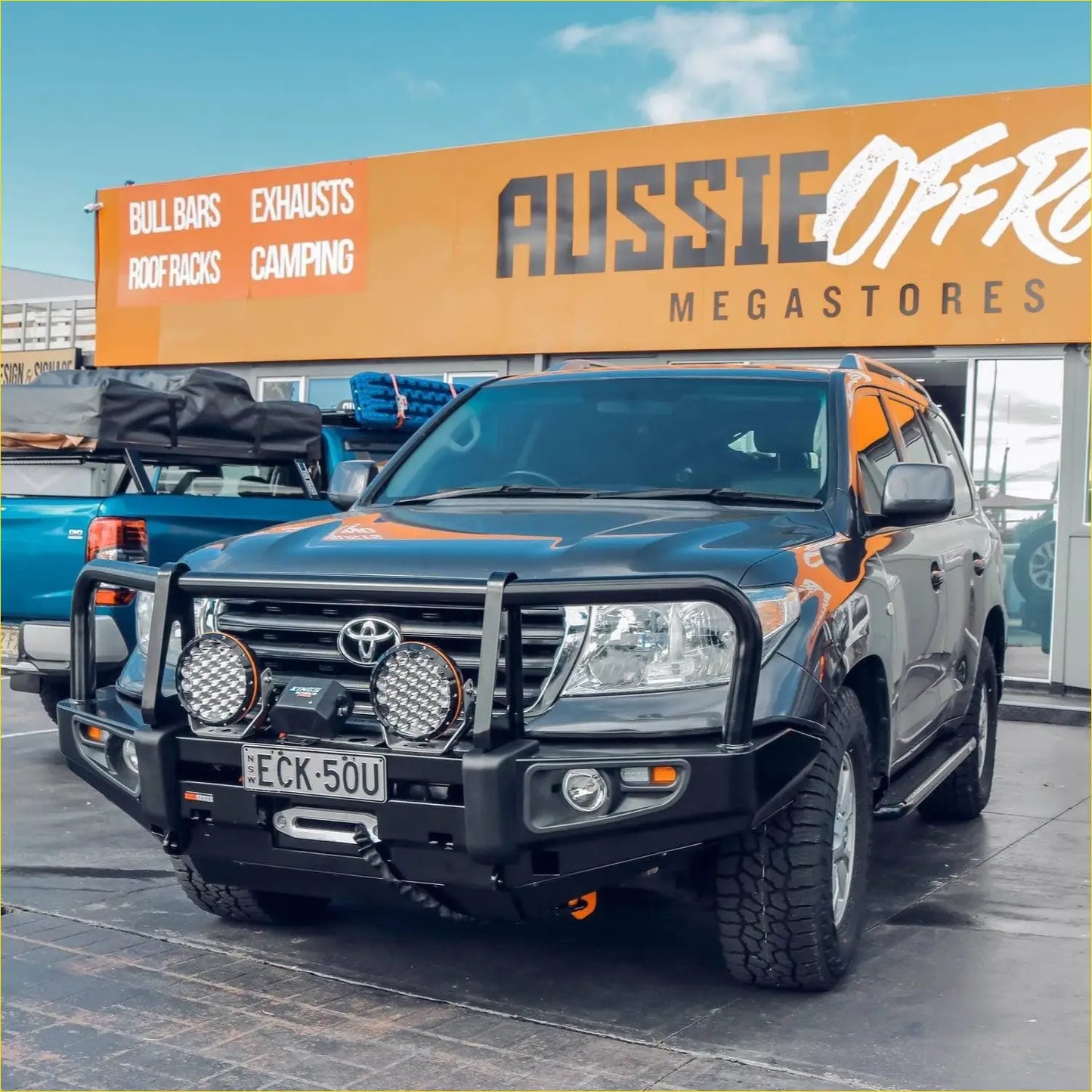 Black toyota land cruiser with rockarmor premium steel bullbar featuring orange accents and rugged bumper with two lights