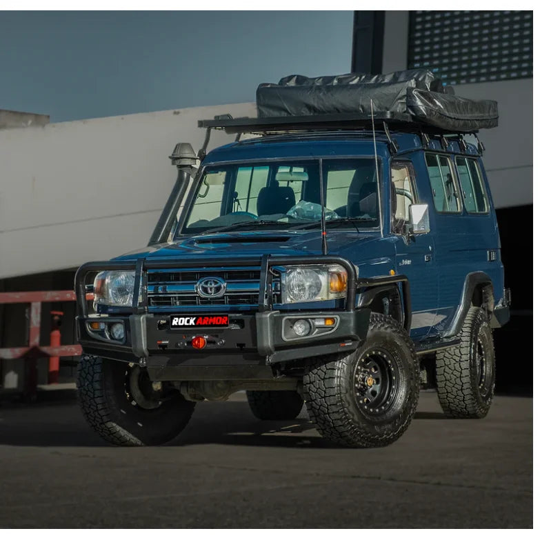 Blue off-road vehicle with roof tent showcasing Rockarmor premium steel bullbar with fog lights