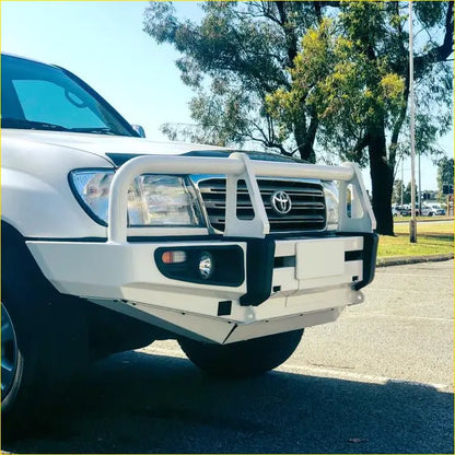 White metal rockarmor premium steel bullbar with black accents mounted on a toyota landcruiser fj100 ifs