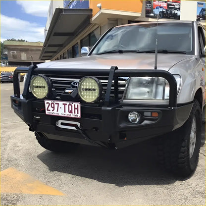 Silver toyota land cruiser with black rockarmor steel bullbar and two circular led lights mounted on front bumper