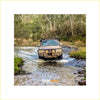 Brown rugged 4wd with rockarmor premium steel bullbar navigating shallow water in forest offroad adventure