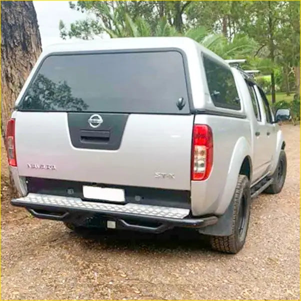 Silver nissan navara ute rear side with black rockarmor premium steel rear step tow bar for offroad 4wd use