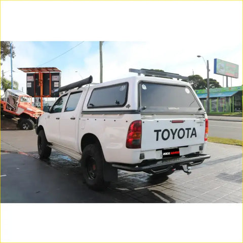 White toyota hilux ute with a hard tonneau cover and rockarmor steel rear step tow bar for offroad 4wd use
