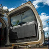 Black hard-shell Rockarmor rear door dropdown table and pantry mounted on the open back door of a Toyota Prado 150