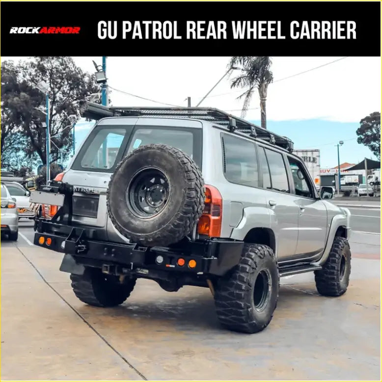 Silver nissan patrol 4wd with black rockarmor steel dual wheel carrier on rear holding spare tire for offroad use