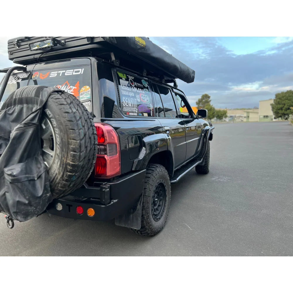 Black off-road vehicle with roof tent showcasing Rockarmor steel dual wheel carrier for Nissan Patrol Y61 Gu4 2004-2016 models and spare wheel fitting video