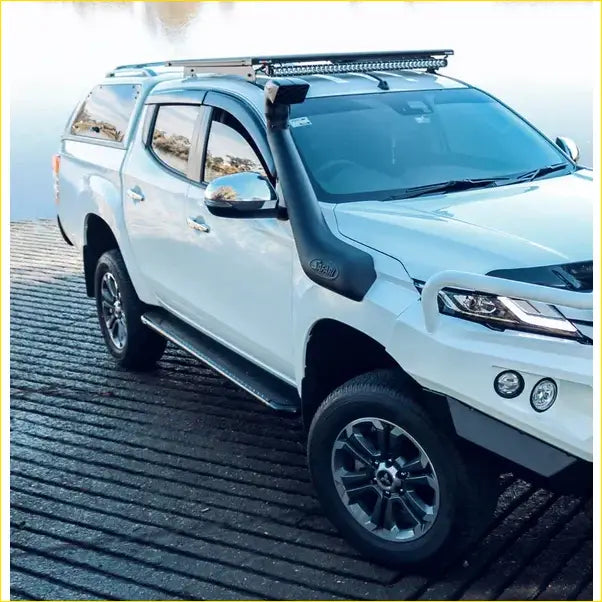 White Mitsubishi Triton pickup with black roof rack and snorkel showing Rockarmor steel rockslider side steps