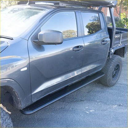 Black metal rockarmor steel rockslider side step with diamond plate finish on dark gray mitsubishi triton mv driver side