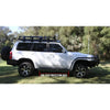 White nissan patrol y61 with rockarmor steel rockslider side steps and roof rack suited for off-road use