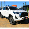 White toyota hilux 4wd ute with black grille featuring rockarmor steel rockslider side steps for offroad use