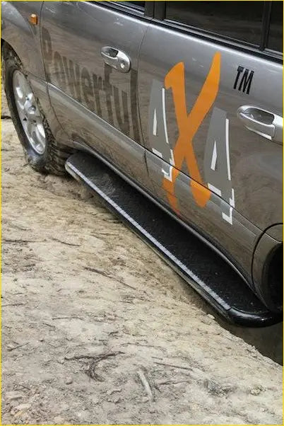 Black rubber rockarmor steel rockslider side step with orange and white powerful 4x4 branding on silver toyota landcruiser