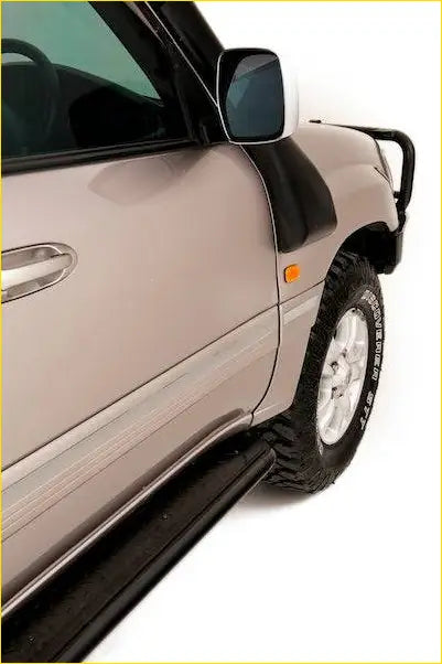 Black rubber rockarmor steel rockslider side step running along lower edge of beige toyota landcruiser suv