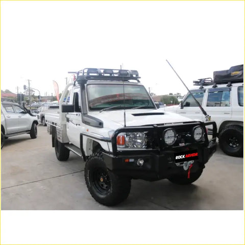 White toyota land cruiser ute with black offroad steel rockarmor rockslider side steps and roof rack for 4wd use