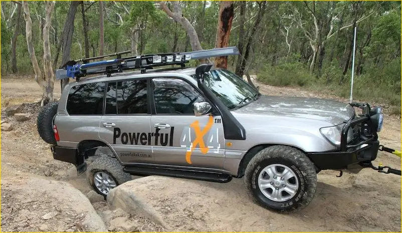 Silver toyota land cruiser 70 series with black roof rack and off-road tires featuring rockarmor steel rockslider side steps
