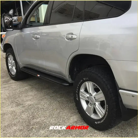 Silver metallic steel rockarmor rockslider side step bar mounted on silver toyota land cruiser for 4wd offroad use