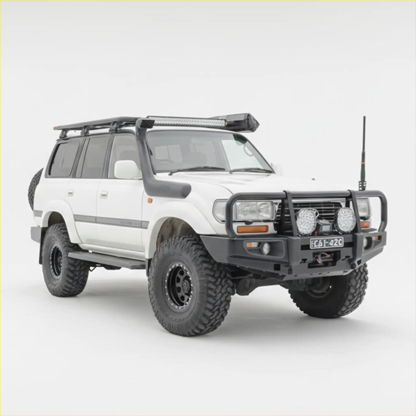 White toyota land cruiser 100 with black rockarmr premium steel bullbar and rugged off-road tires