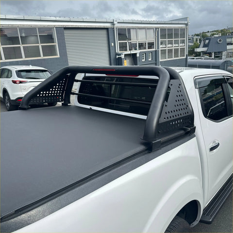 Black perforated steel roll bar sport bar with integrated side rails mounted on the back of a white isuzu d-max truck