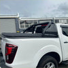Backside of black soft tonneau cover with integrated roll-up and perforated metal railings on white toyota hilux 2015-2020