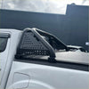 Black perforated metal roll bar with curved tubular bars and brackets for toyota hilux 2015-2020 truck bed rail back view