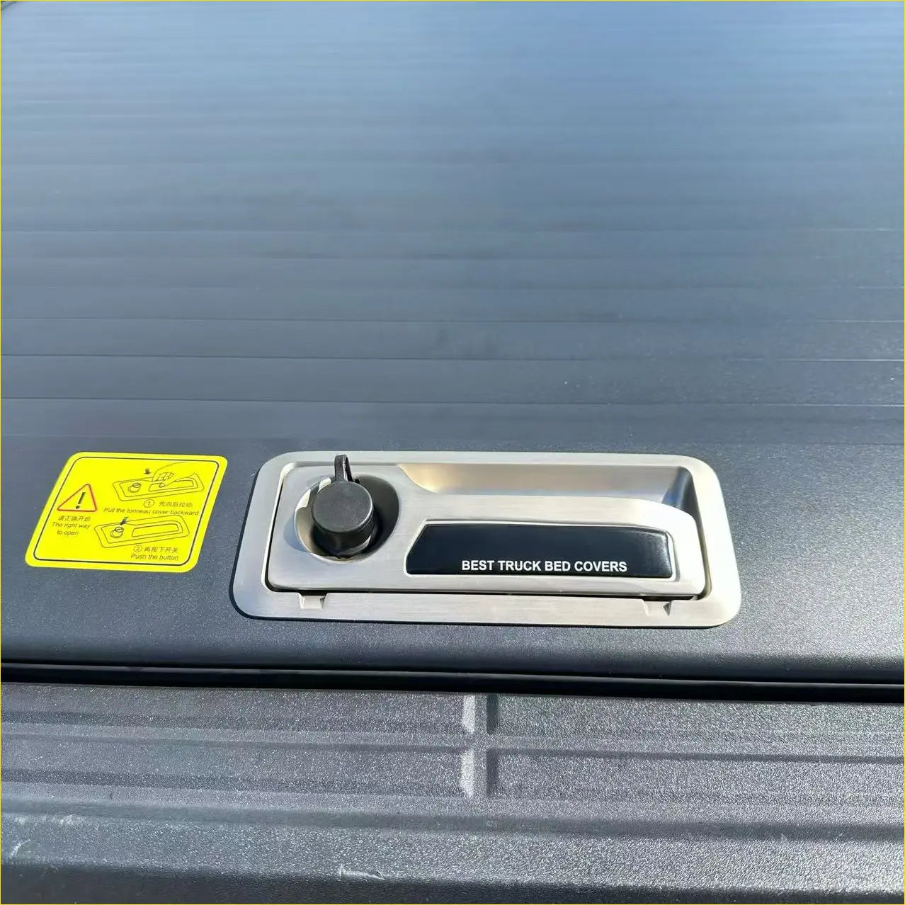 Silver-trimmed black knob handle on the back side of roll bar t10 manual roller shutter for ford ranger 2022 plus truck bed cover