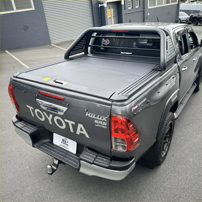 Gray toyota hilux sr5 limited with black manual roller shutter and roll bar t10 shown from the back side