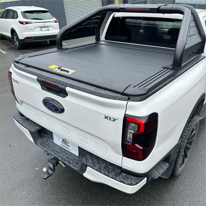 Black retractable textured tonneau cover with integrated handle on white ford ranger xlt back side roll bar t20 manual shutter