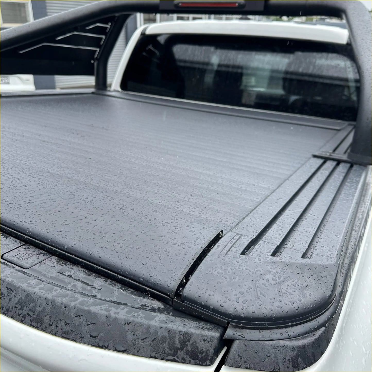 Black, textured, retractable truck bed cover with a sleek, modern design.