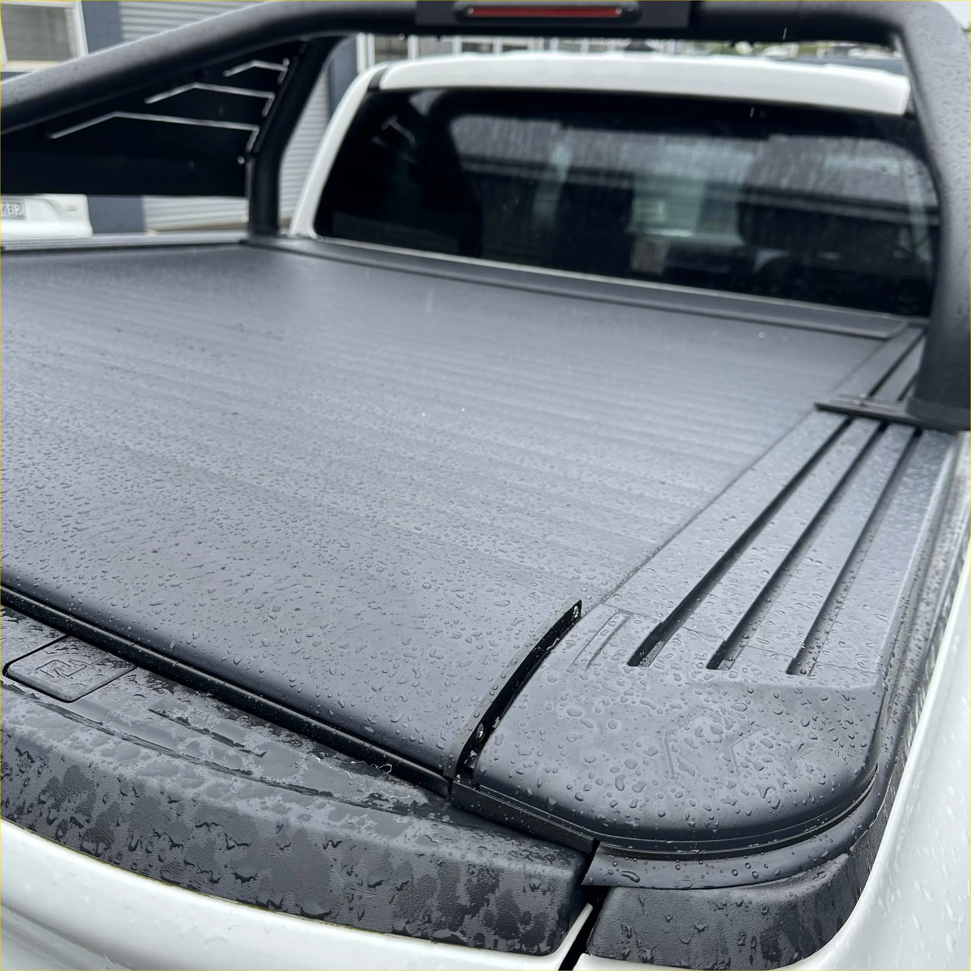 Black, textured, retractable truck bed cover with a sleek, modern design.