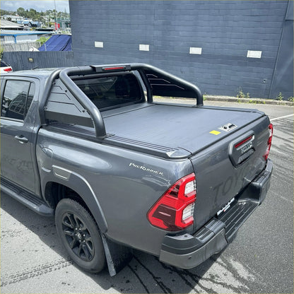 Backside of gray Toyota Hilux prerunner with black manual roller shutter roll bar T20 and rear rack 2015-2025 model