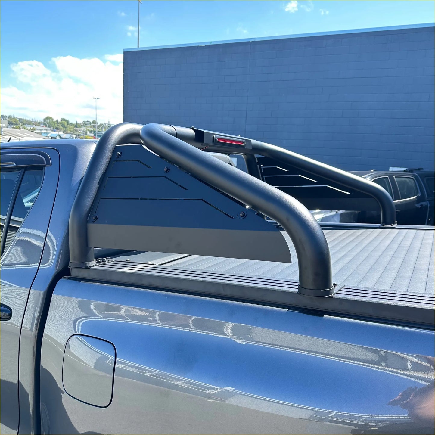 Back view of black tubular steel roll bar t20 truck bed rail with integrated red led light for toyota hilux 2015-2025