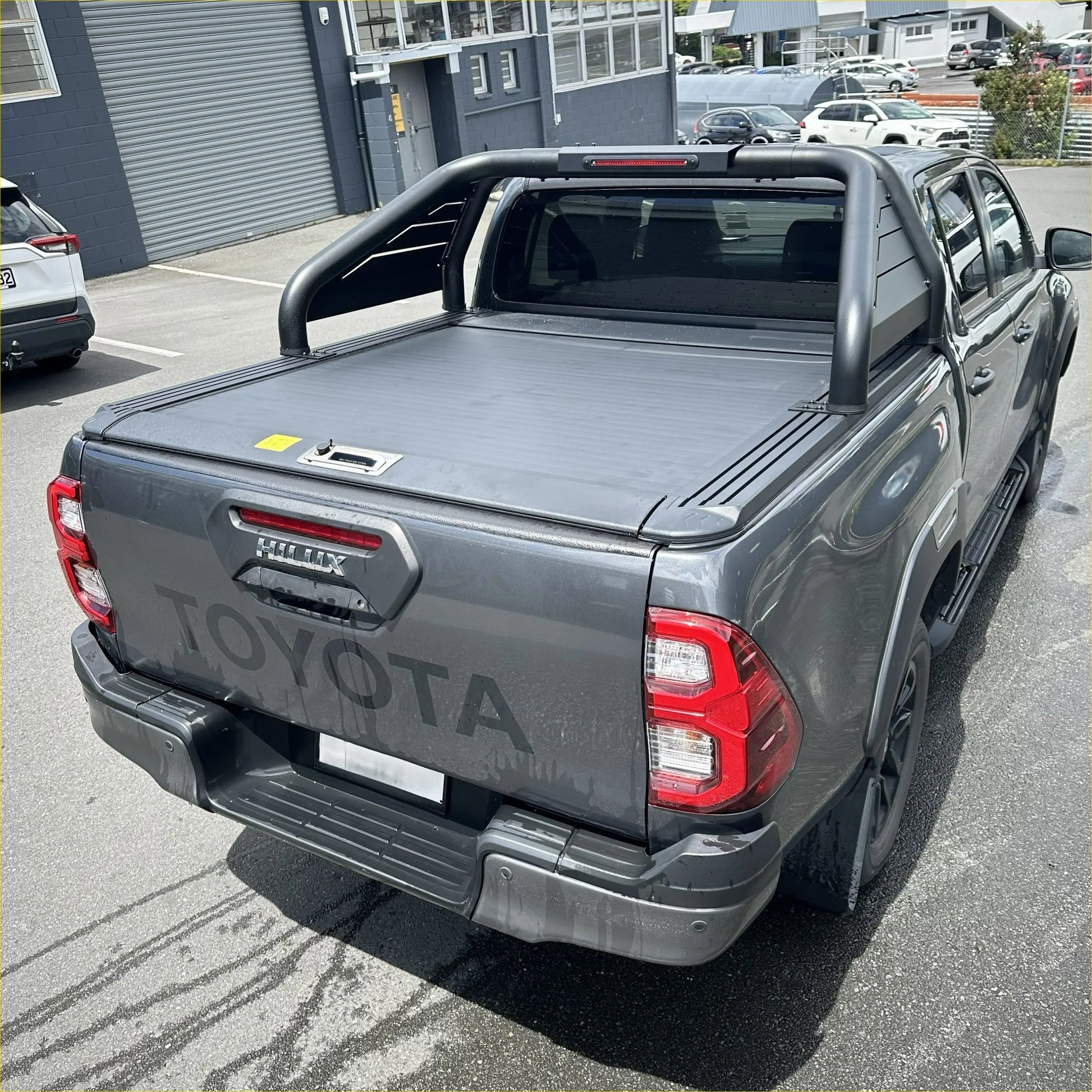 Back view of gray toyota hilux with black manual roller shutter and roll bar t20 for 2015-2025 models