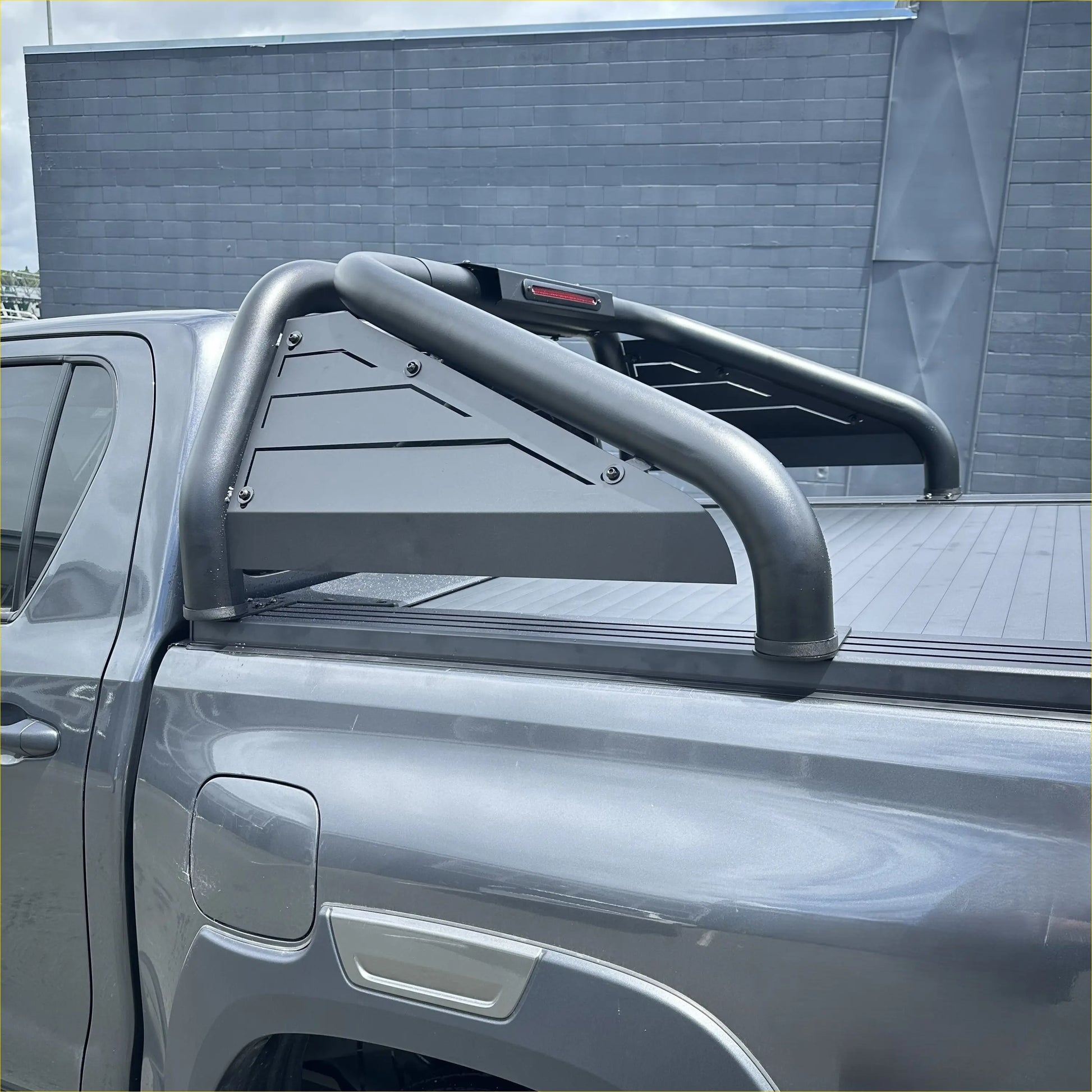 Backside of black metal roll bar t20 with angular cutouts and red taillight for toyota hilux 2015-2025