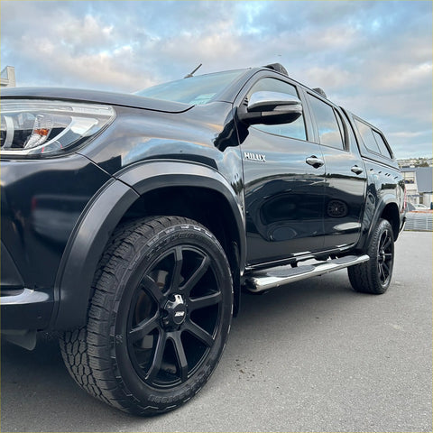 Black toyota hilux with matte black wheels showing the back side of the 4 inch oval tube stainless steel running board