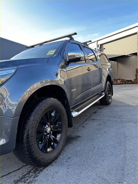 Dark gray metallic colorado double cab pickup with black alloy wheels and roof rack shown from the side step running board