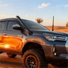 Dark gray metallic toyota hilux pickup truck with black stainless steel snorkel and rugged off-road tires for 2015+ models