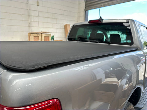 Black fabric soft tonneau cover on silver 2012-2020 holden colorado double cab shown from the back side